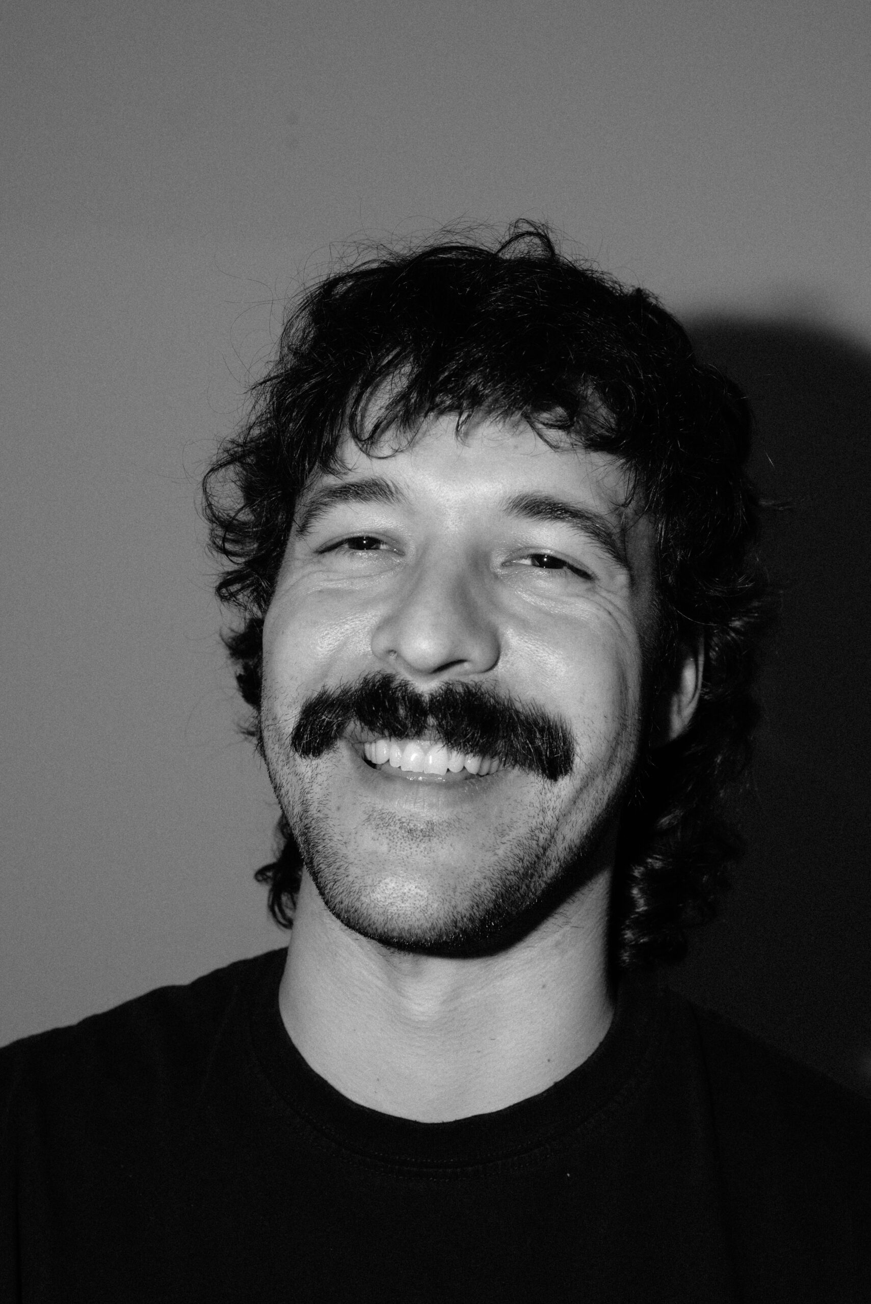 luke kokoszka portrait in black and white, smiling showing teeth